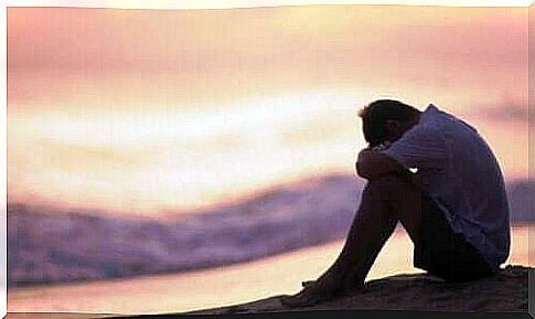 A sad man sitting by the beach and thinking about external emotion regulation