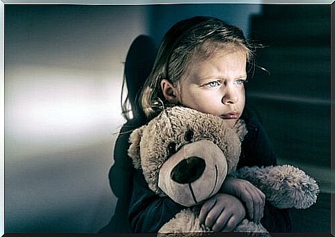 Sad girl hugging her teddy bear