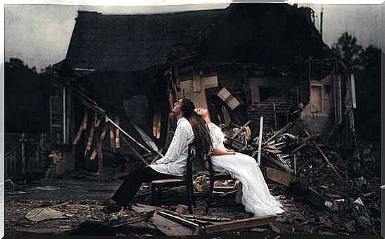 Couple in front of ruined house