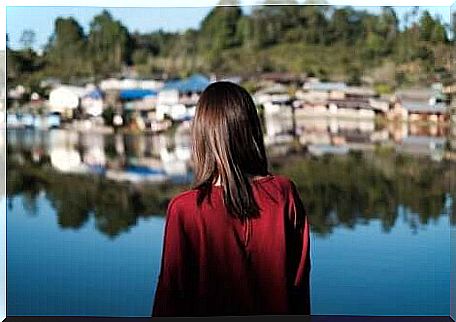 A woman looking over a lake towards a small village