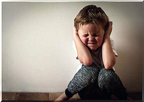 Boy holding his ears.