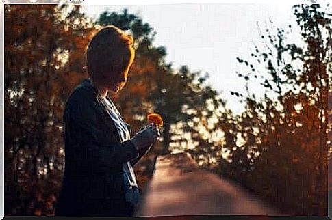 A woman looking at a flower